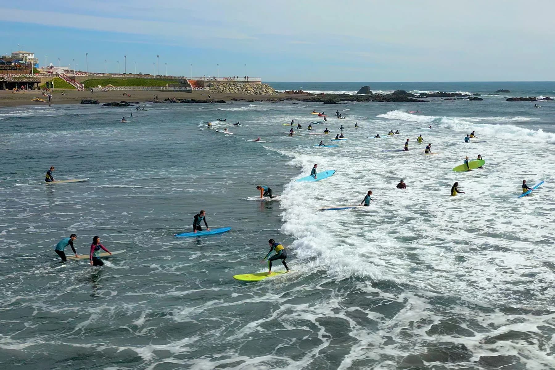 Surfistas de la escuela entrando a las olas de La Puntilla